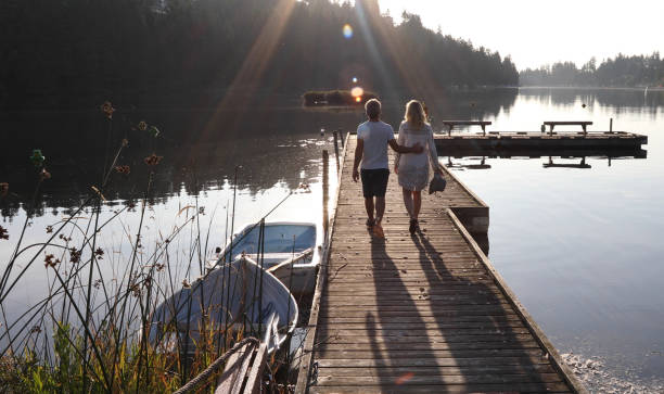 istock Couple walk along lakeside pier at sunrise 1173388553