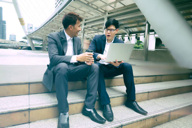 istock Businessmen Discussing While Sitting On Staircase In City 1173397392