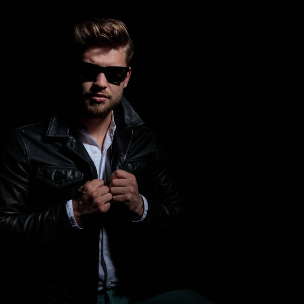istock cool young man in leather jacket and sunglasses closes coat 1173403041