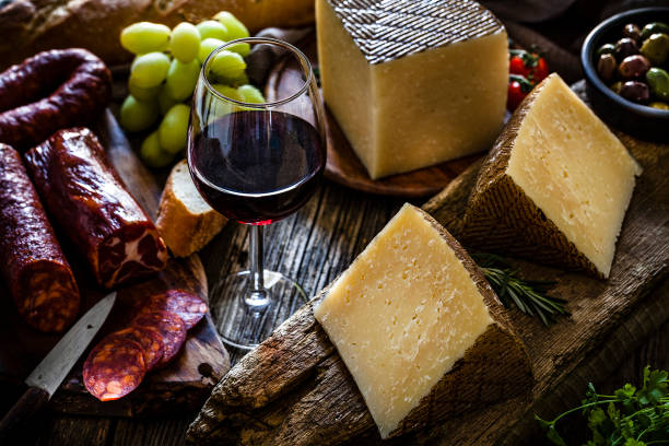 alimento espanhol: queijo de manchego, chorizo espanhol, vinho vermelho e azeitonas na tabela de madeira rústica - spanish cuisine - fotografias e filmes do acervo