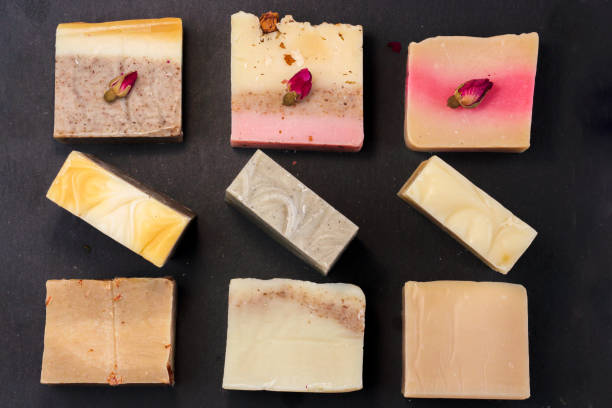 istock handmade multicolored soap with herbs and rosebuds on a black background with a blank space for text. Spa soap for face and body treatments flat lay istagram  style 1173404594