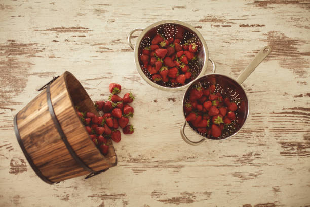 Bucket and sieves full of strawberries