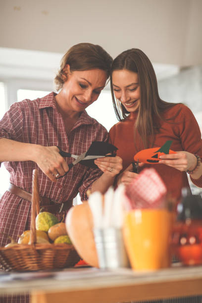 istock Girl and mother preparing Halloween decorations in kitchen 1173405794