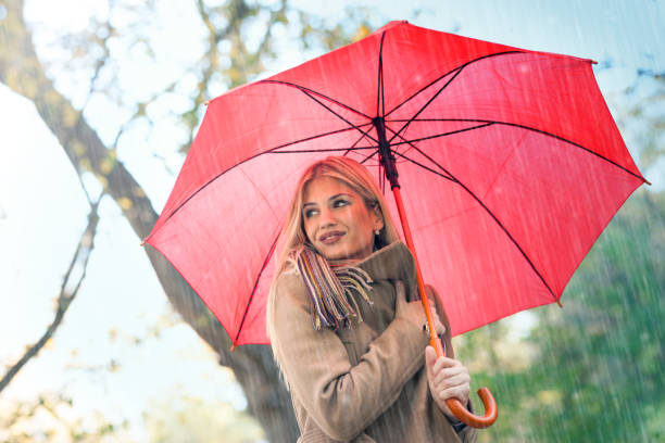 istock Cheerful pretty girl holding umbrella while strolling outside. 1173406220
