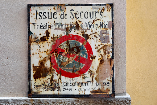 Nice, France - September 24, 2018: Prohibition sign appears to be significantly worn out, partially is rusty and there are many inscriptions on it
