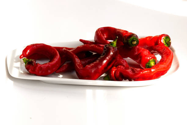 Long sweet peppers intertwined on plate