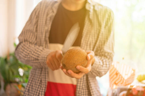 person with big knife try to open and break a coconut