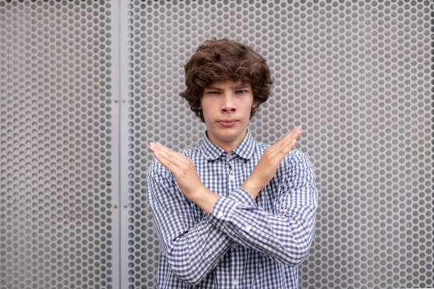 young man with crossed hands in front of face, stop gesture sign