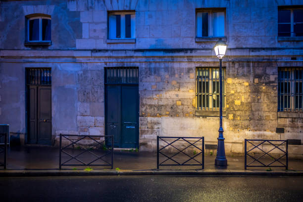 das licht der einsamen straßenlaterne auf der abendstraße von paris nach dem regen - sidewalk cafe stock-fotos und bilder