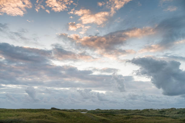 дюна пейзаж, закат у моря, красивое голубое облачное небо, контраст, свет, тень, идиллический, маррам грасс, песчаные дюны, амеланд, голландск - nes стоковые фото и изображения