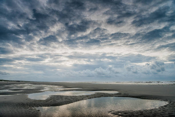 paisaje marino, puesta de sol en la costa, hermoso cielo azul nublado, contraste, luz, sombra, idílico, reflejo en el agua, mar norte holandés, costa, ameland, isla de wadden, frisia, los países bajos - nes fotografías e imágenes de stock