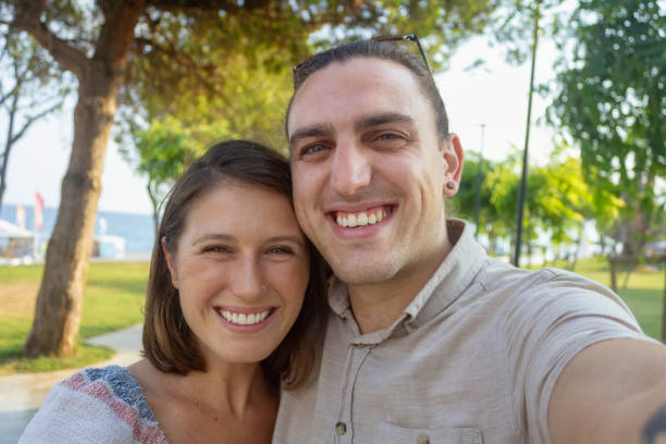 istock Young couple taking a selfie on the beach park 1173424222