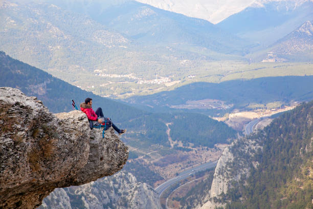 istock Young man with backpack standing on edge cliff on top of mountain. 1173427165