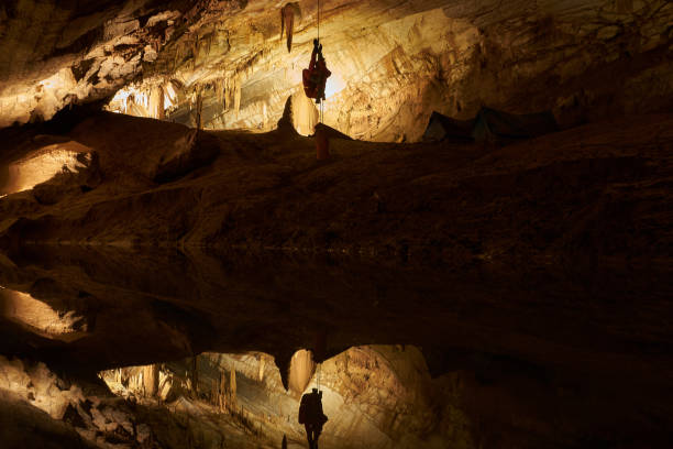 istock Speleologist Hanging On A Rope In A Cave With Reflexion On The Water 1173429599