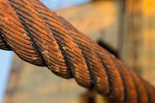 Old rusty twisted wire metal cable closeup of the mount from the excavator