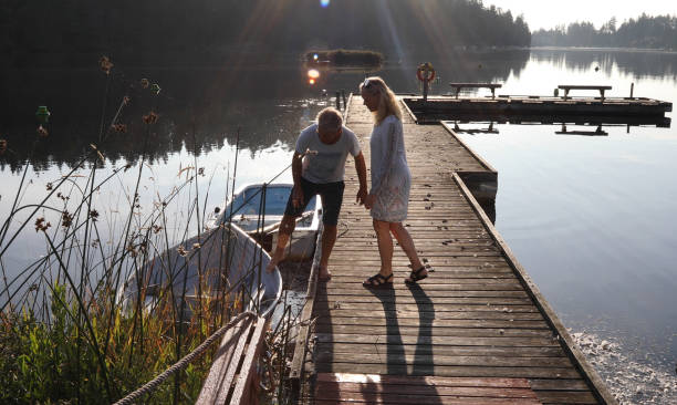 istock Couple walk along lakeside pier at sunrise 1173436761
