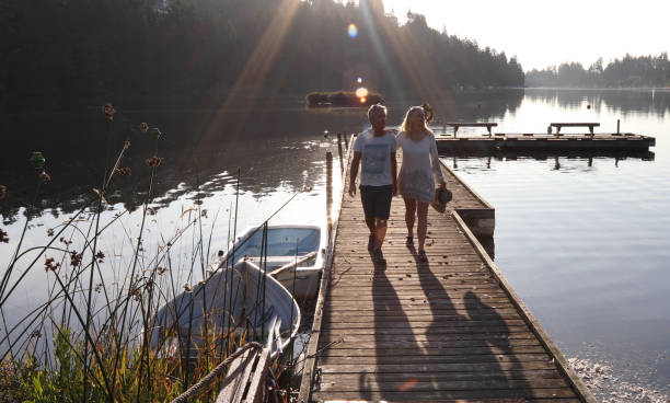 istock Couple walk along lakeside pier at sunrise 1173436762