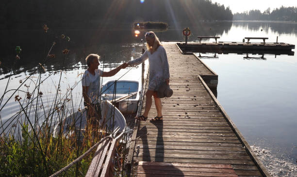 istock Couple walk along lakeside pier at sunrise 1173436791