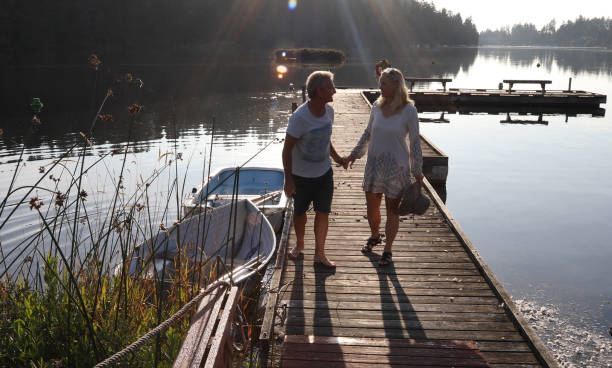istock Couple walk along lakeside pier at sunrise 1173436806
