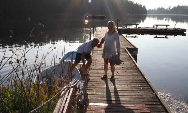 istock Couple walk along lakeside pier at sunrise 1173436829