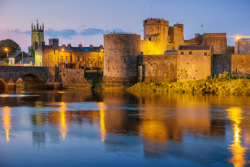 King John's Castle and River Shannon in downtown Limerick, Ireland illuminated at night.