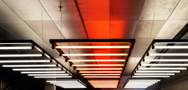 Ceiling with hanging down neon tubes. Lighting for halls, offices and large buildings stock photo