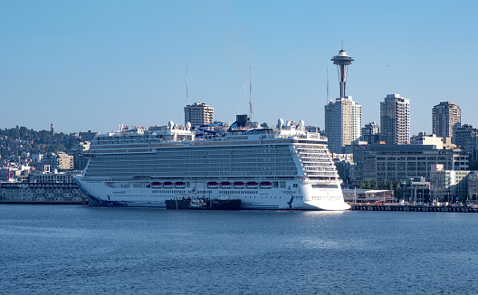 Cruise ship docked in Seattle, WA - August 5, 2019: large cruise liner with Seattle skyline behind it.