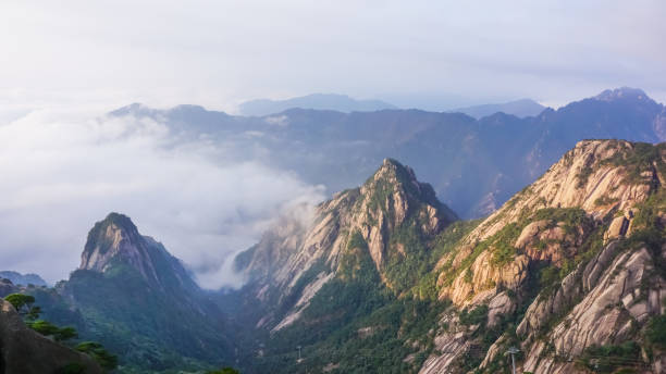 Yellow mountains in the fog at dawn of the sun Yellow mountains in the fog at dawn of the sun. Huangshan National Park in China huangshan mountains stock pictures, royalty-free photos & images