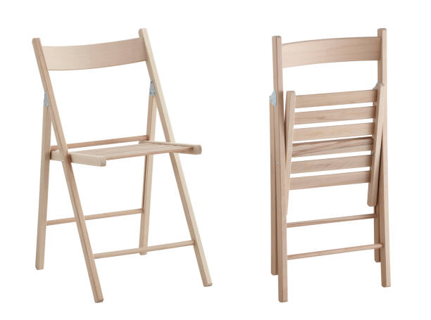 A black folding chair with a black seat and a black back. The chair is sitting on a wooden floor