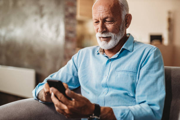 hombre mayor y su smartphone - typebar fotografías e imágenes de stock