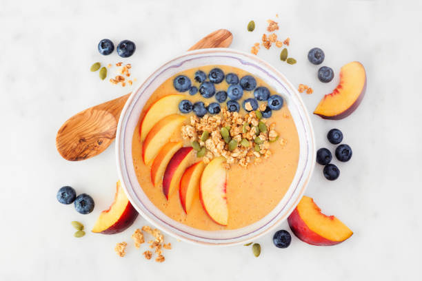 istock Peach smoothie bowl with blueberries and granola, above view scene on marble 1173452742