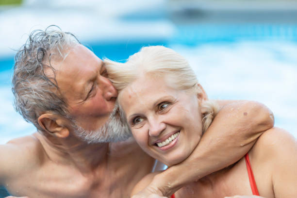 istock Senior Couple On Holiday In Swimming Pool 1173454838