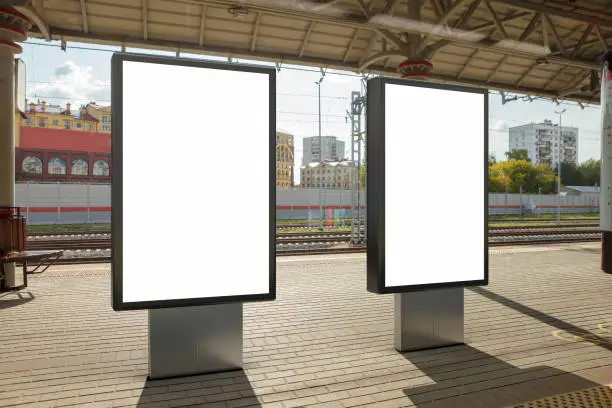 Two blank billboard poster stands mock up on platform of railway station. 3d illustration.