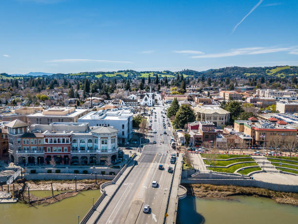 Aerial View of Downtown Napa and Riverfront An aerial view of downtown Napa, California on a sunny day. The bridge over Napa River and the Riverfront promenade are in the foreground. waters edge stock pictures, royalty-free photos & images