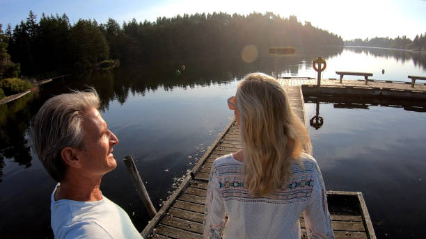 istock Couple walk along lakeside pier at sunrise 1173475373