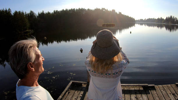 istock Couple walk along lakeside pier at sunrise 1173475388