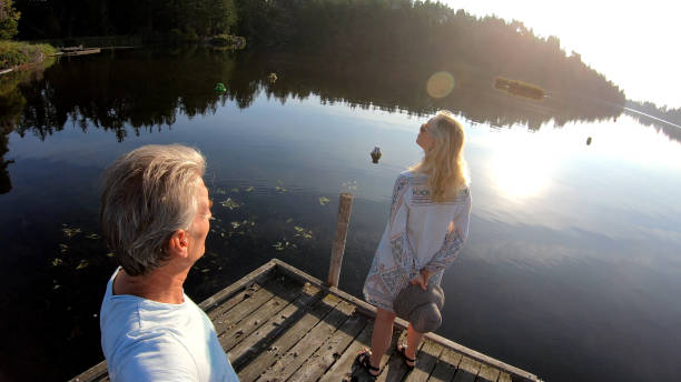 istock Couple walk along lakeside pier at sunrise 1173475391
