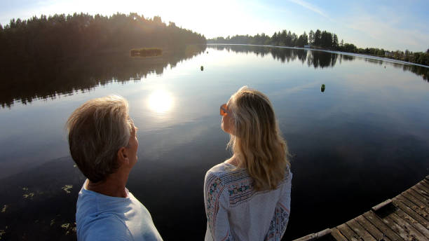 istock Couple walk along lakeside pier at sunrise 1173475405