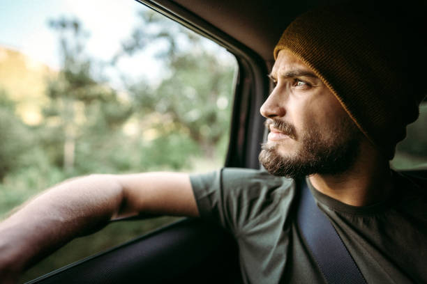 Handsome man with knit cap driving in car