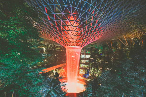 аэропорт jewel changi, сингапур - 30 июля 2019 г.: jewel changi airport rain vortex. самый большой крытый водопад в мире. вид на вихрь дождя ночью. - changi стоковые фото и изображения