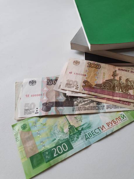 istock Russian banknotes of different denominations and stacked books 1173479027