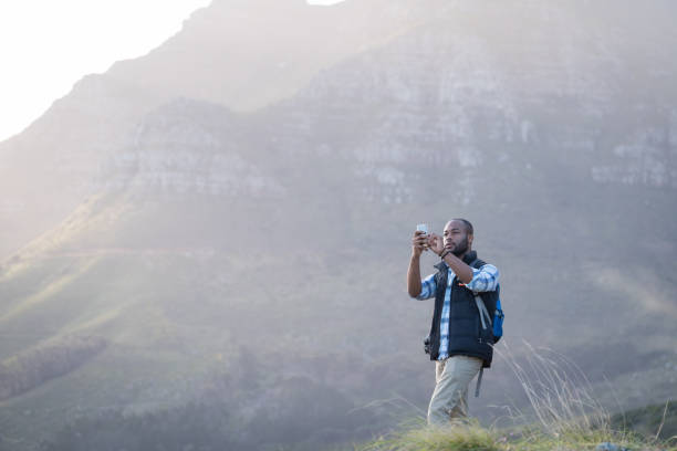 istock Man standing on cliff against rocky mountains 1173480755