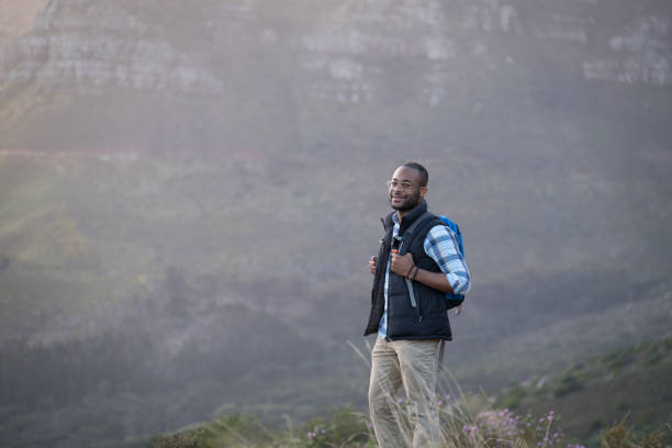 istock Male hiker on cliff against rocky mountains 1173484125