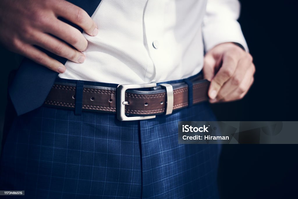 Buckle up, you're about to get married Cropped shot of a man wearing a belt with his jeans and shirt on his wedding day Belt Stock Photo