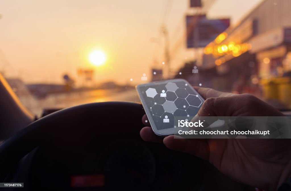 Close up of a man using mobile smart phone with map icon in car at sunset ,Business connection network concept,copy space. Searching Stock Photo