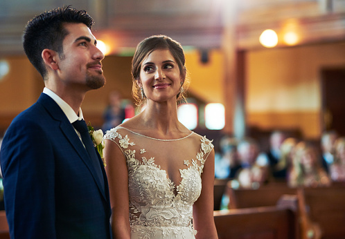 Shot of a young bride looking fondly at her groom during the wedding ceremony