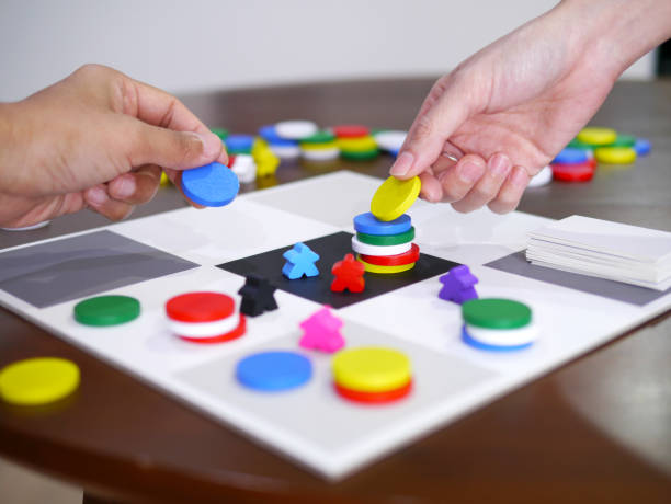 les gens jouant jeu de société amusant sur le dessus de table en bois a choisi le foyer - meeple photos et images de collection