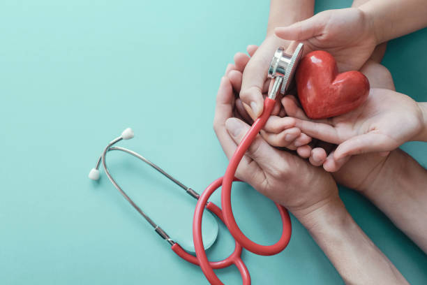 聴診器、心臓の健康、健康保険の概念、世界の心臓の日、世界の健康の日で赤い心を保持する家族の手 - love hope valentines day horizontal ストック��フォトと画像