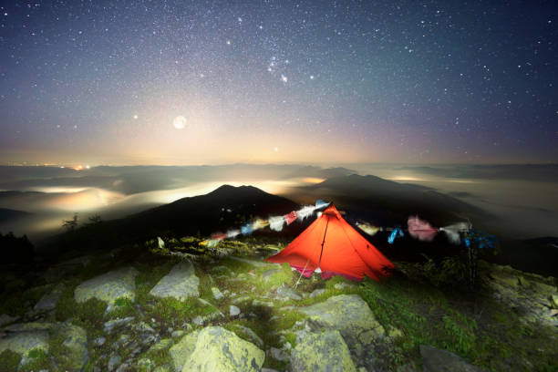 Himalayas, Alps, Carpathians, you can meet tourists Buddhist travelers. Climber red tent in the mountains under the starry sky, Buddha flags in the wind.