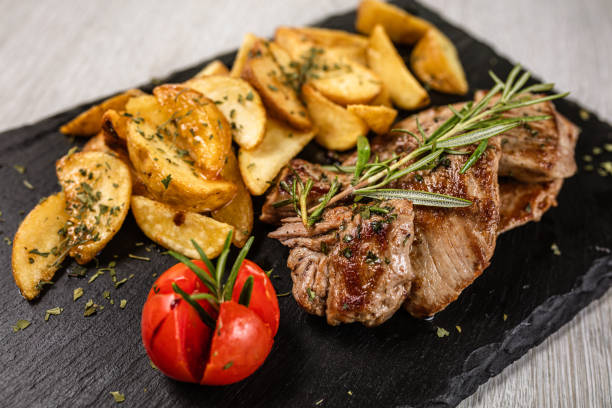 istock Pork chops in honey sauce with baked tomatoes 1173499866